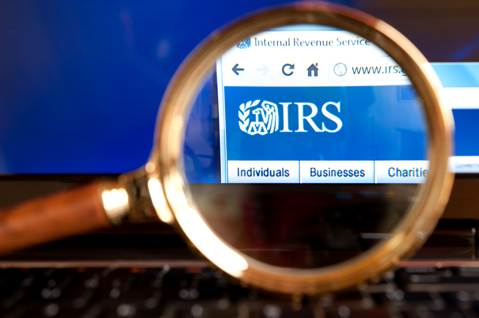 IRS-website-through-a-magnifying-glass-171307444 Close up to IRS( Internal Revenue Service) website through a magnifying glass on the laptop.